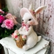 Vit kanin med rosa hatt och blommor